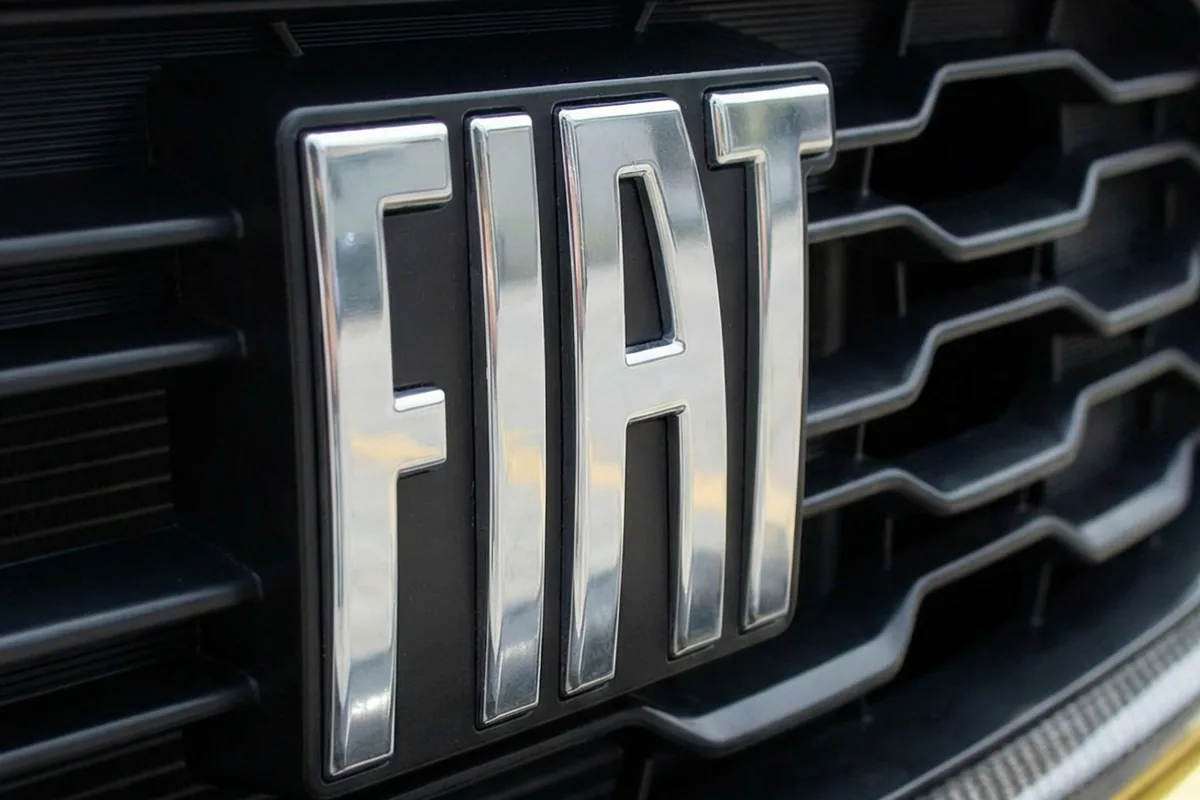 Close-up do emblema FIAT prateado na grade frontal preta do Fiat Torino 147 Concept.