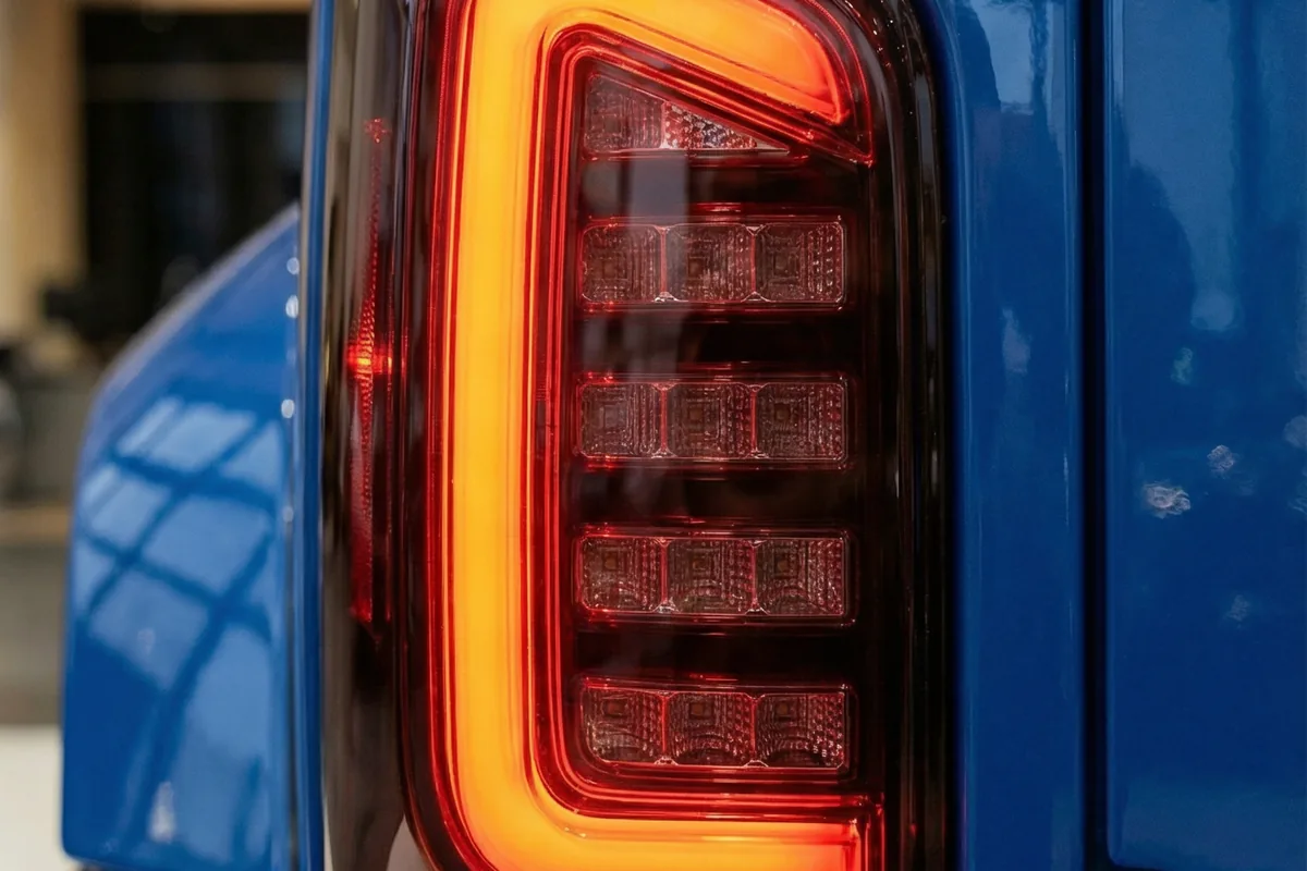 Detalhe da lanterna traseira vertical com iluminação LED em tons de vermelho e laranja no Kingpin.
