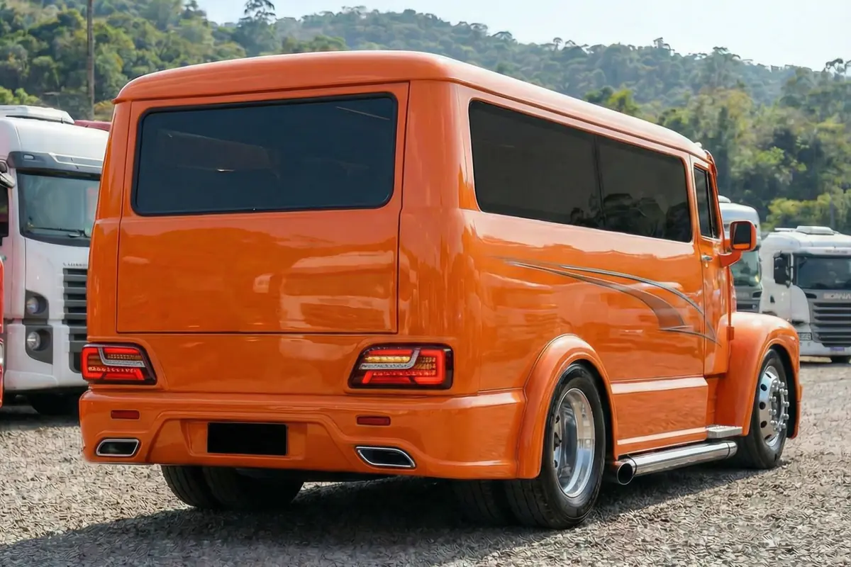 Van customizada Scania 111S laranja, vista traseira 3/4. Lanternas LED modernas, escapamento duplo, rodas.