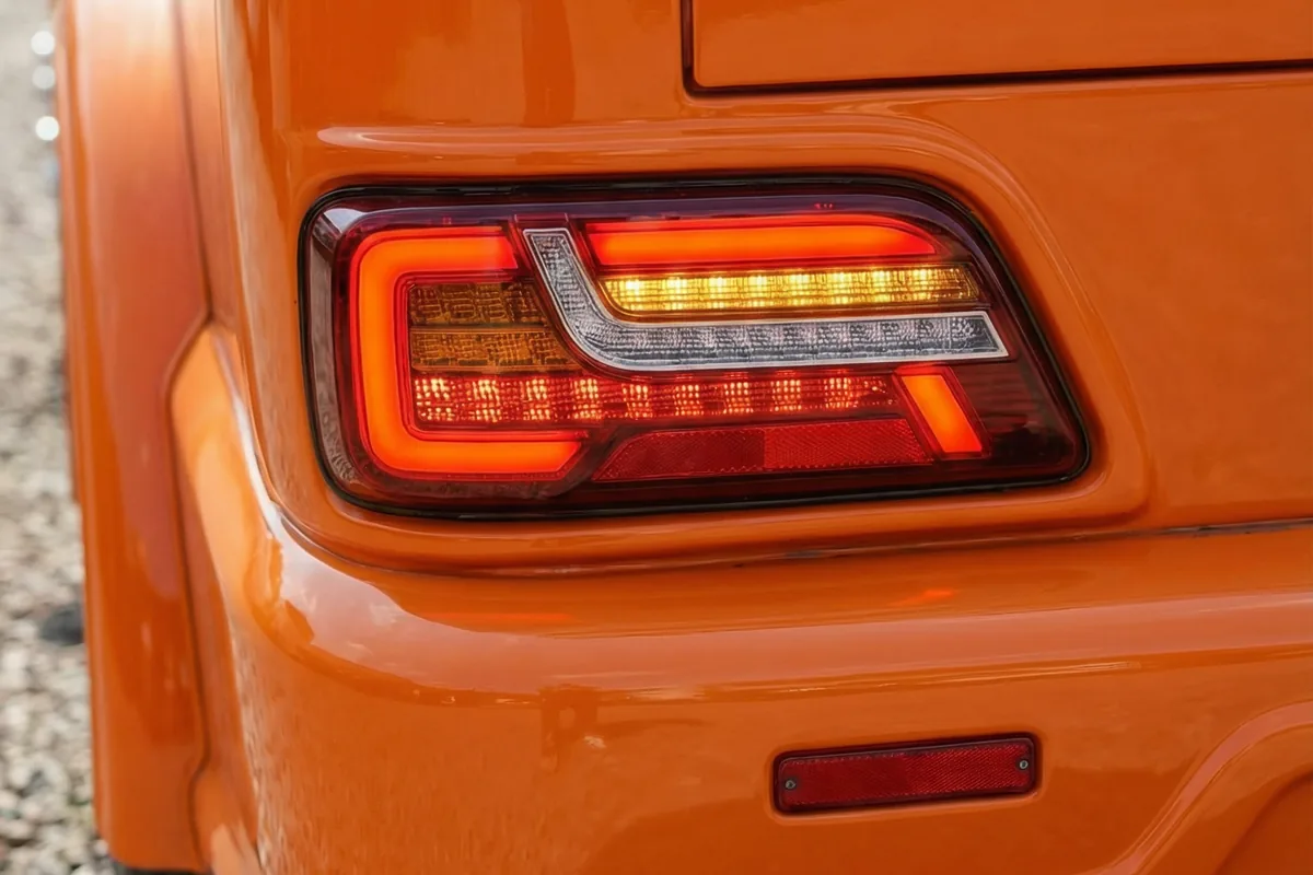 Close-up da lanterna traseira de LED retangular com múltiplas faixas de luz e acabamento cromado da Scania 111S.