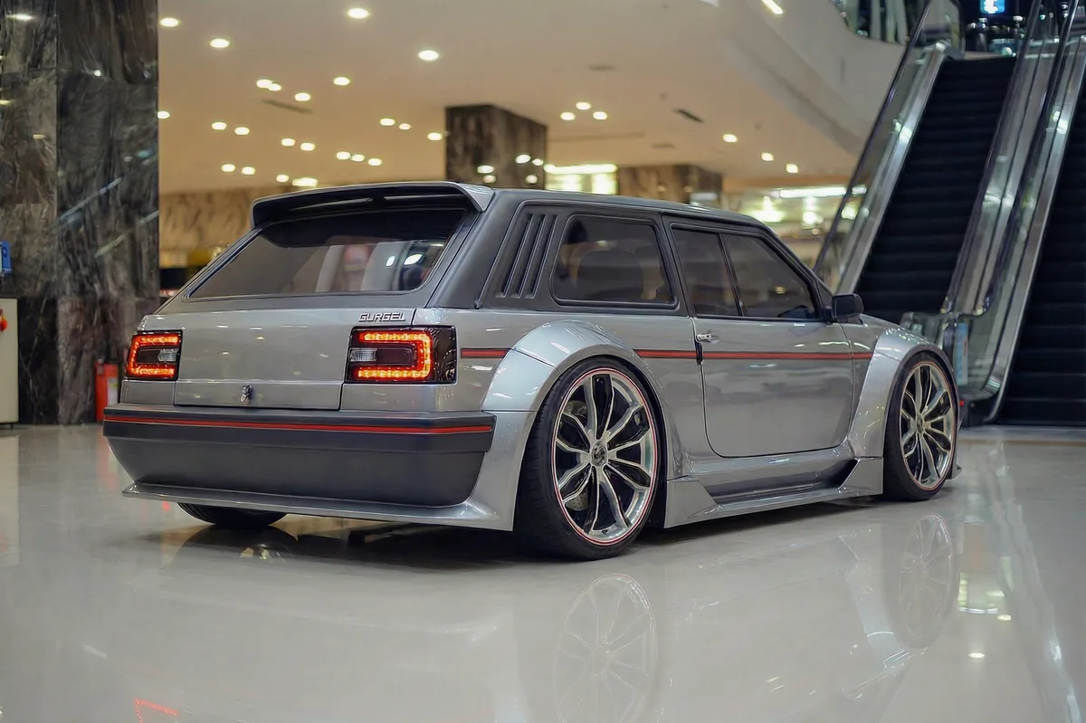 Gurgel BR800 EV restomod prateado visto de traseira 3/4, com lanternas LED e spoiler, em showroom.