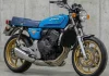 CG com Motor Hornet: O Conceito “CG 600 RS” da IA Motocicleta Honda CG customizada azul com motor de Hornet 600cc, rodas douradas e design retrô em garagem.