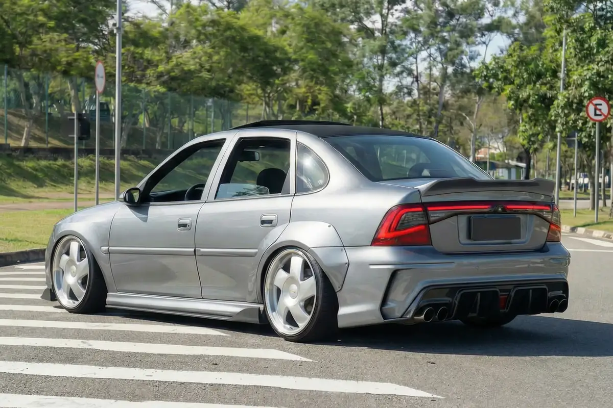 Chevrolet Vectra restomod cinza, rebaixado, traseira redesenhada com difusor, escape quádruplo e lanternas modernas.