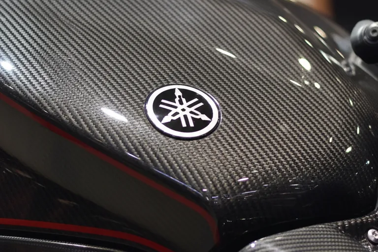 Close-up do tanque em fibra de carbono da Yamaha XJ6 X com emblema da Yamaha e friso vermelho