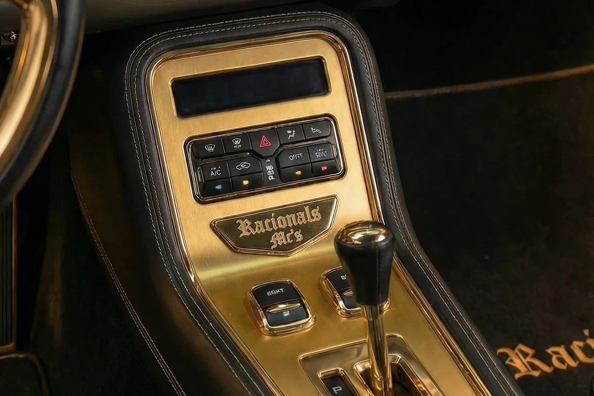 Console dourado do Impala conceito, com placa gravada, comandos e alavanca de câmbio.