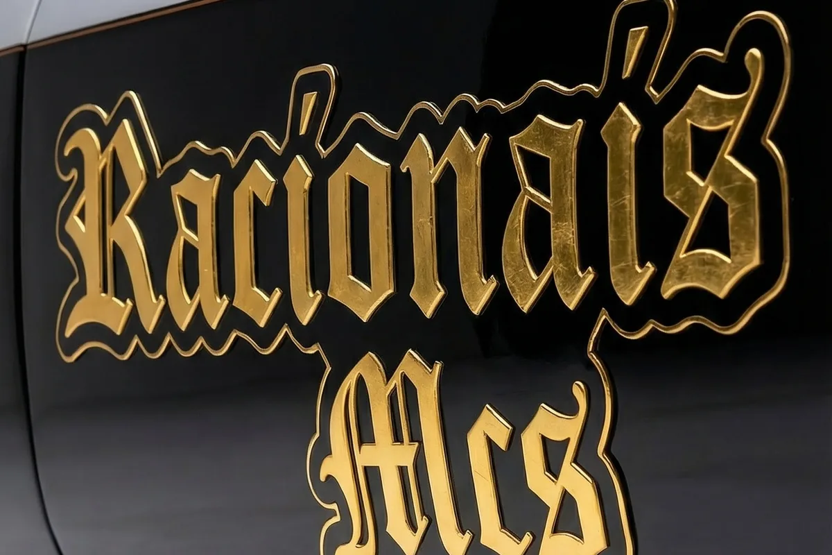 Nome Racionais MC's em letra gótica dourada com contorno, sobre a pintura preta da lateral.