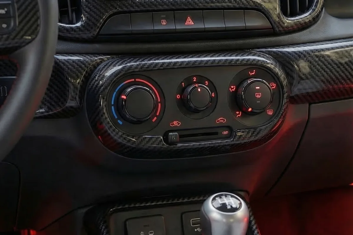 Console da Fiorino conceito com comandos físicos de ar-condicionado em anéis vermelhos e câmbio manual.