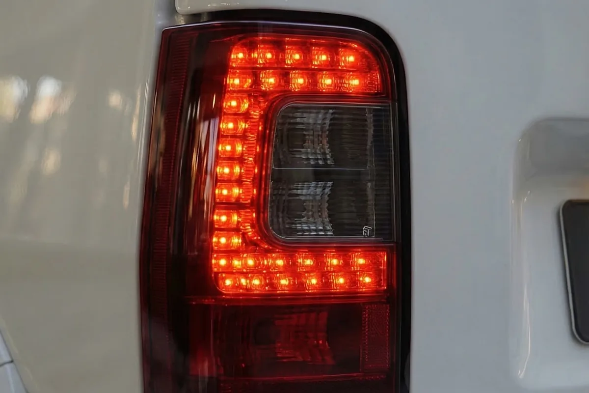 Lanterna traseira em LED desenhada em C, acesa em vermelho, na lataria branca da Fiorino conceito.
