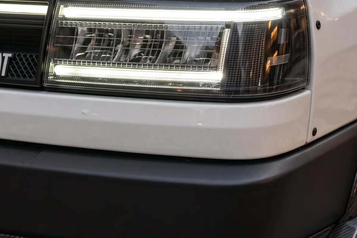 Farol do Fiat Uno conceito em detalhe, com assinatura de LED horizontal dentro de carcaça escura.