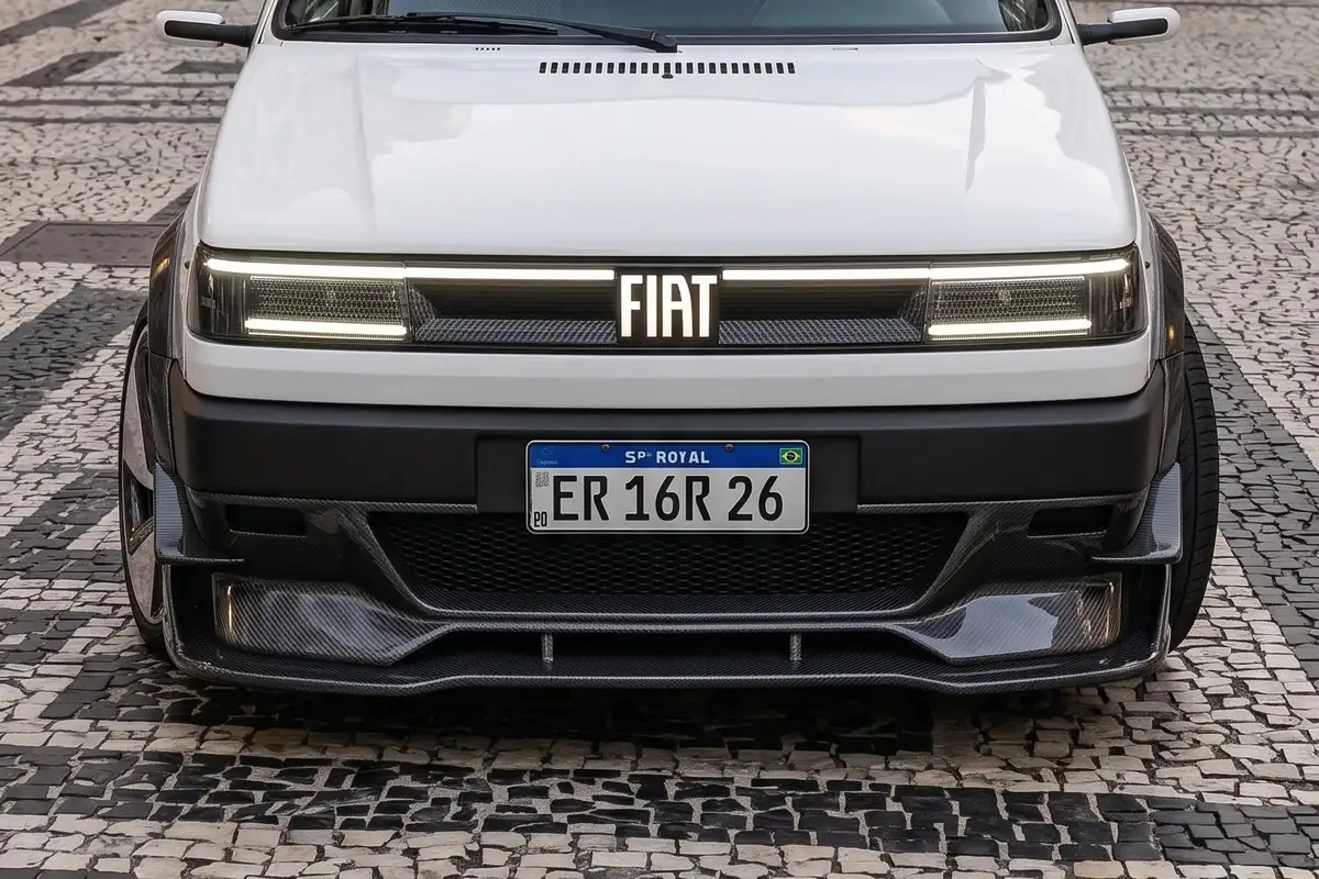 Vista frontal reta do Fiat Uno elétrico branco, com faixa de LED contínua e para-choque preto fosco.