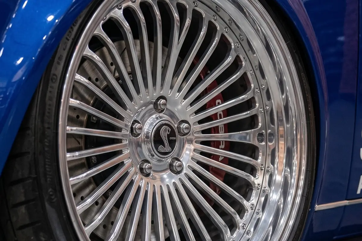 Roda de raios finos com aba polida e emblema da cobra no cubo, no Ford Corcel Shelby.