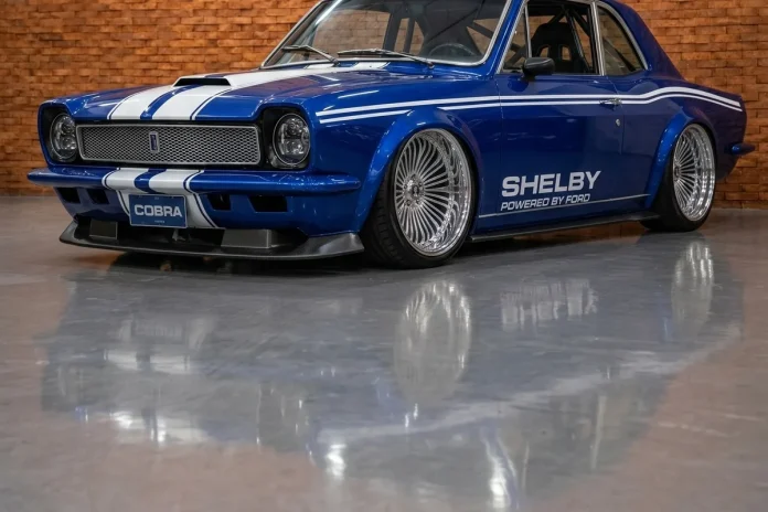 Ford-Corcel-Shelby-Restomod-14 Ford Corcel azul com faixas brancas Shelby em conceito digital, visto em três quartos num galpão de tijolo aparente.