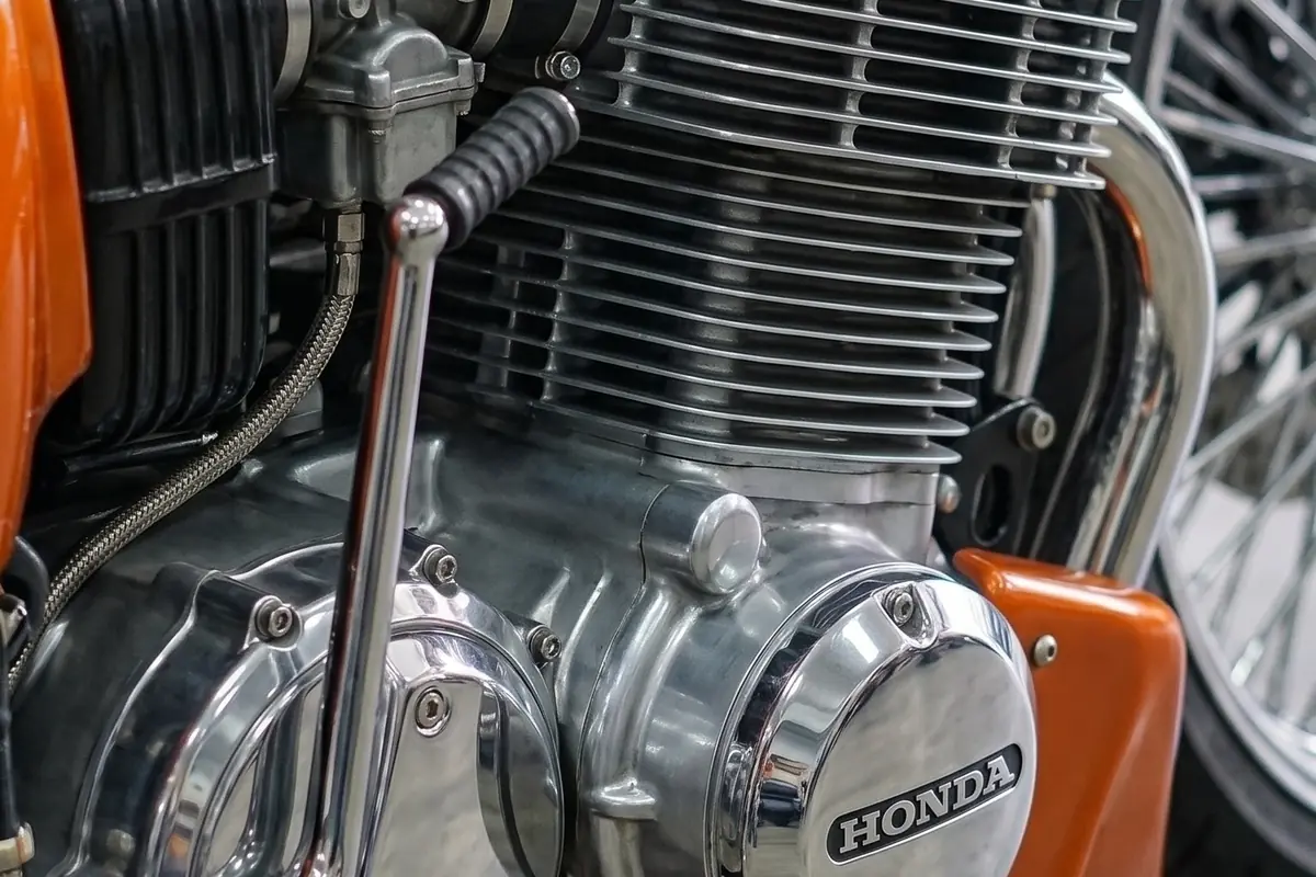 Motor quatro cilindros em linha refrigerado a ar da Honda CB 750, com aletas e carburadores à vista.