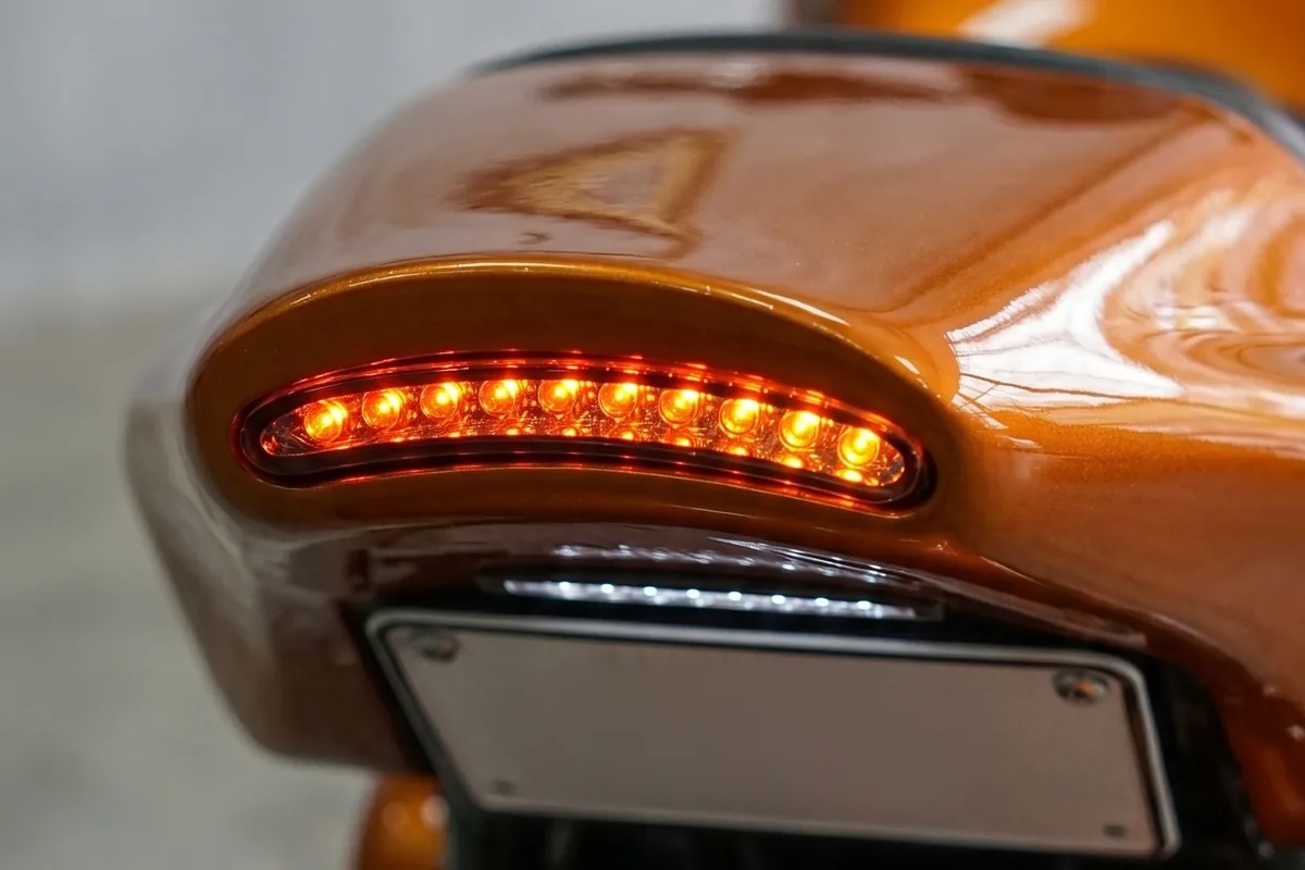 Traseira do conceito Honda CB 750 com para-lama curto e faixa de LED vermelha acesa.
