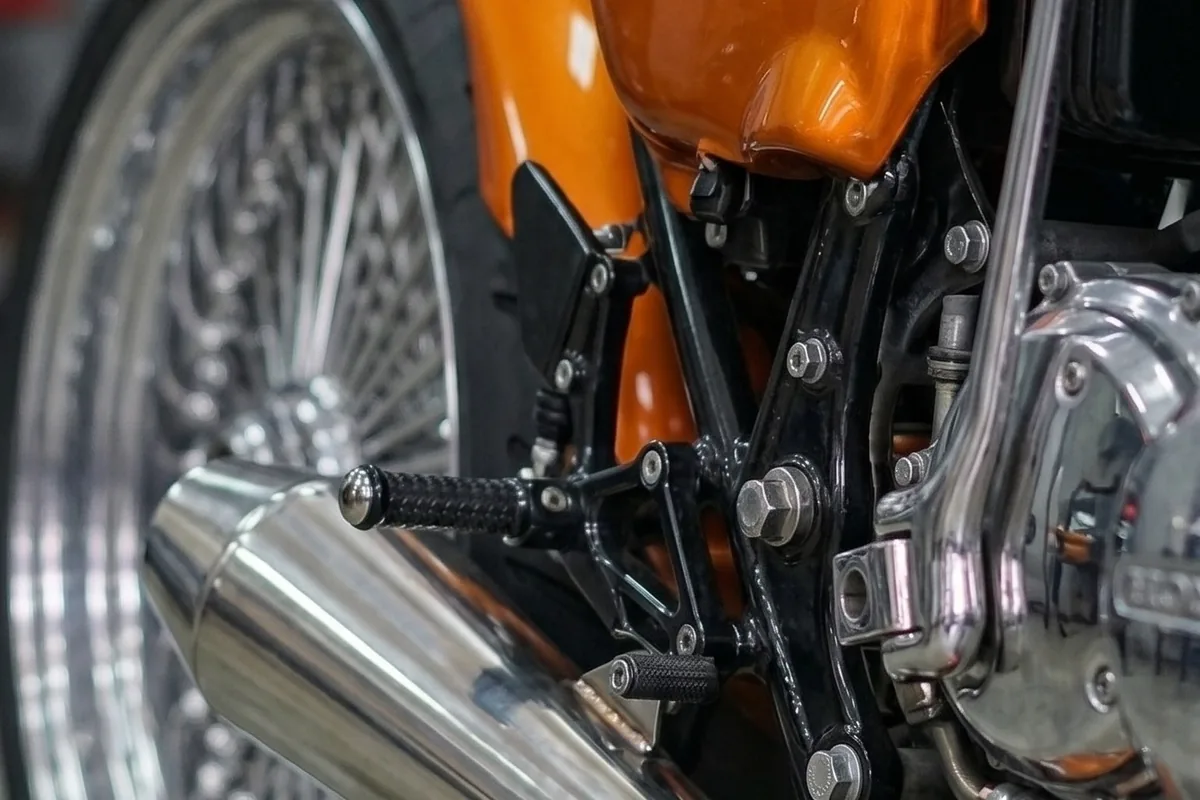 Escapamento em aço polido do conceito Honda CB 750, com curva longa e ponteira reta.