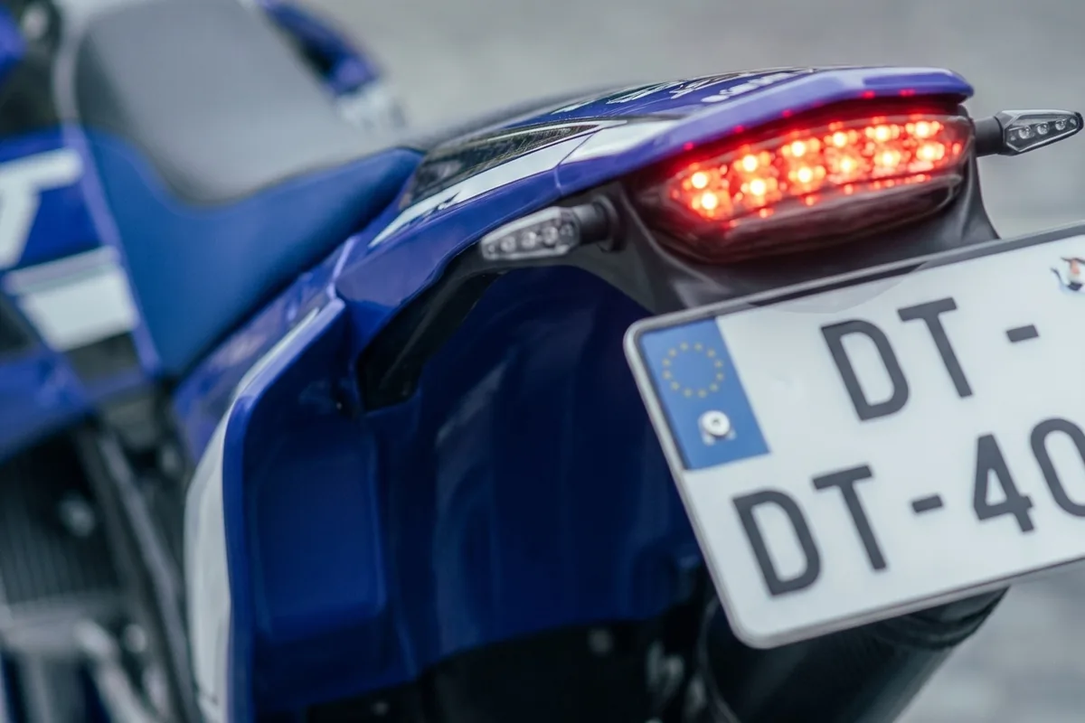 Traseira da DT 400 R com rabete curto, lanterna em LED acesa e placa em suporte próprio.