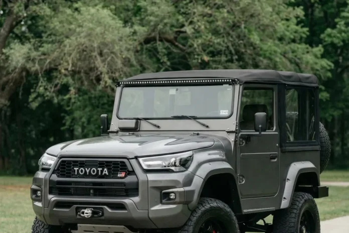 Toyota Bandeirante cinza fosco em conceito GR Sport, visto em três quartos dianteiro numa estrada de terra.