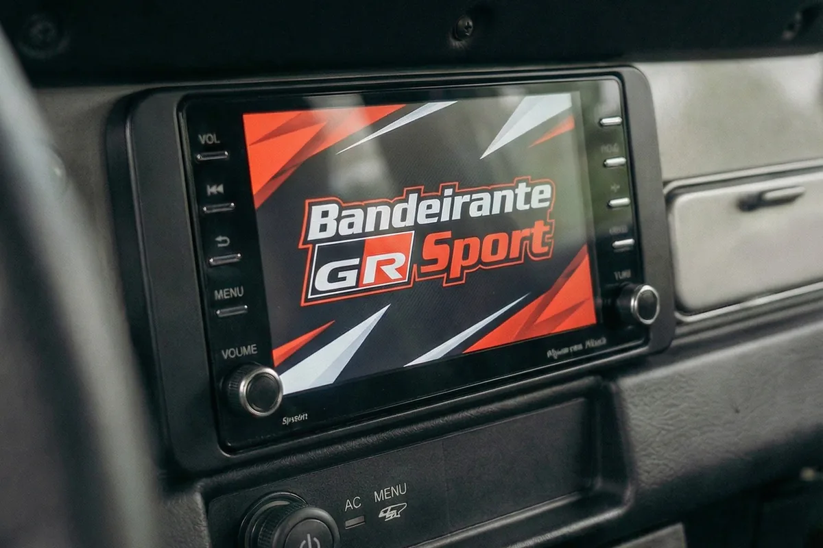Tela colorida no console do Bandeirante conceito exibindo Bandeirante GR Sport sobre grafismo vermelho.