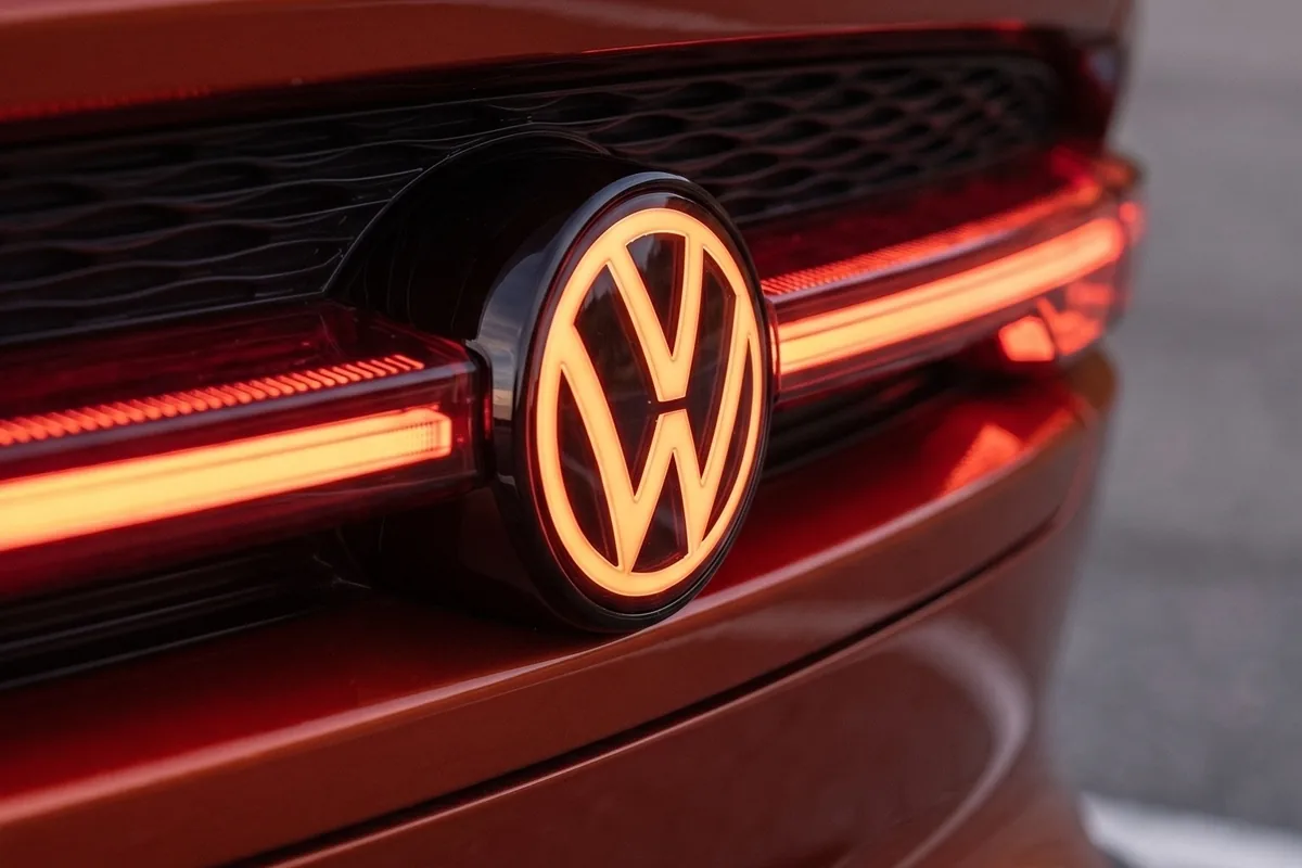 Traseira do VW SP2 EV com logotipo VW iluminado em laranja entre lanternas de LED vermelhas acesas