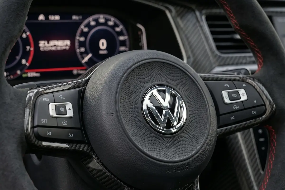 Volante de fibra de carbono do Santana conceito, com emblema da Volkswagen no centro e painel digital atrás.